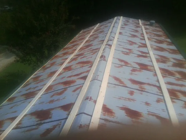 Rusted metal roof panels with new wood purlins before replacement — Storm Damage Roof Repair in Patriot by Roofing Brothers