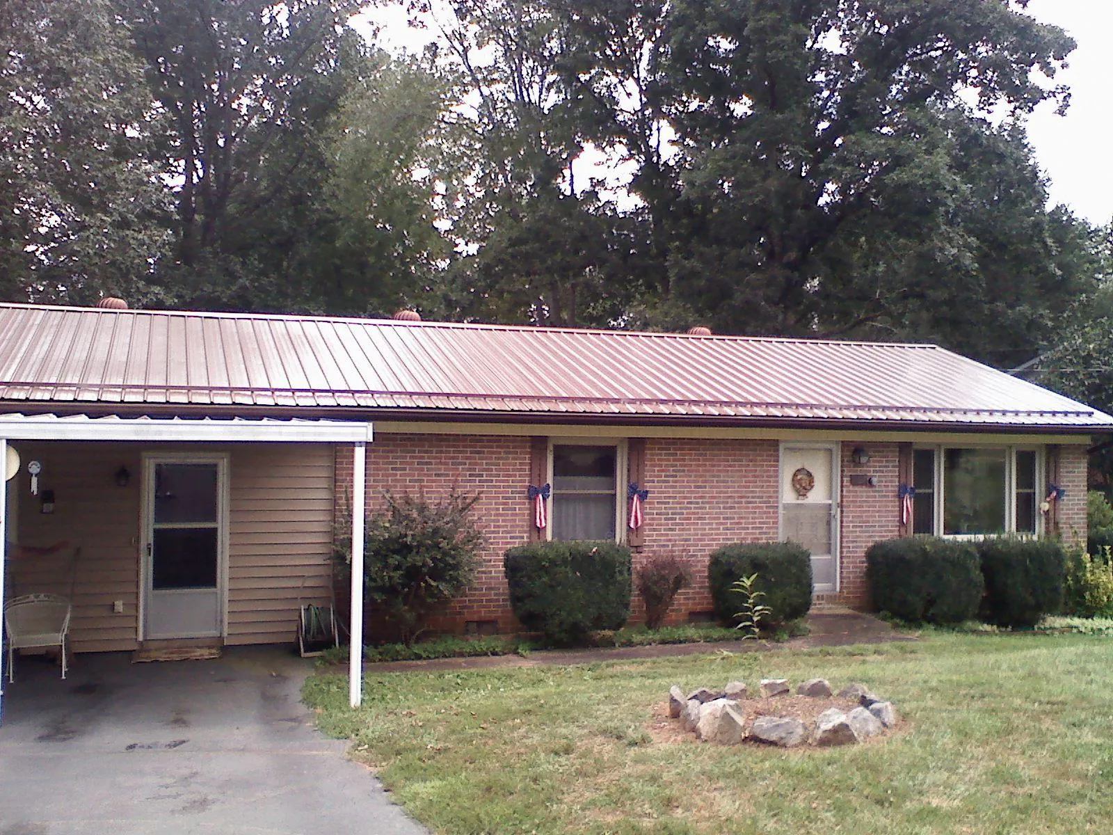Bronze metal roof and carport on a brick ranch home — Roof Repair work by our crew in Patriot