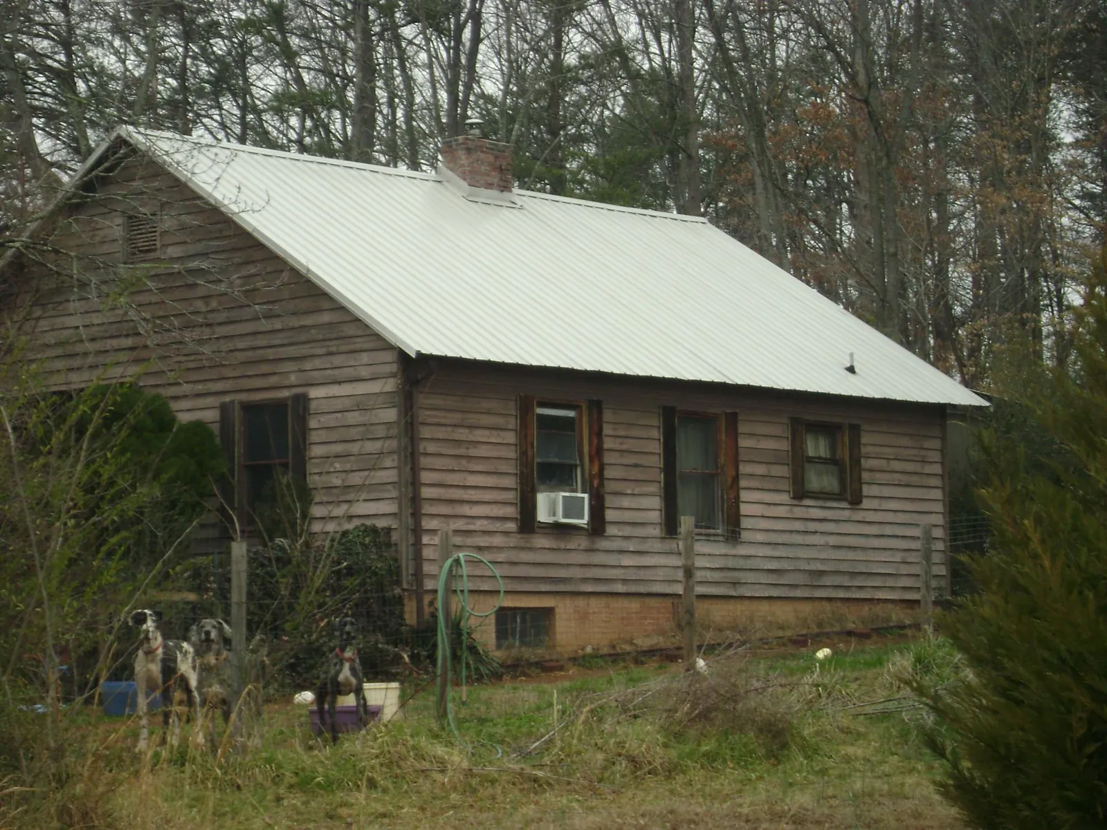 White metal roof on an old wood sided farmhouse, from a Metal Roof Installation job in Patriot